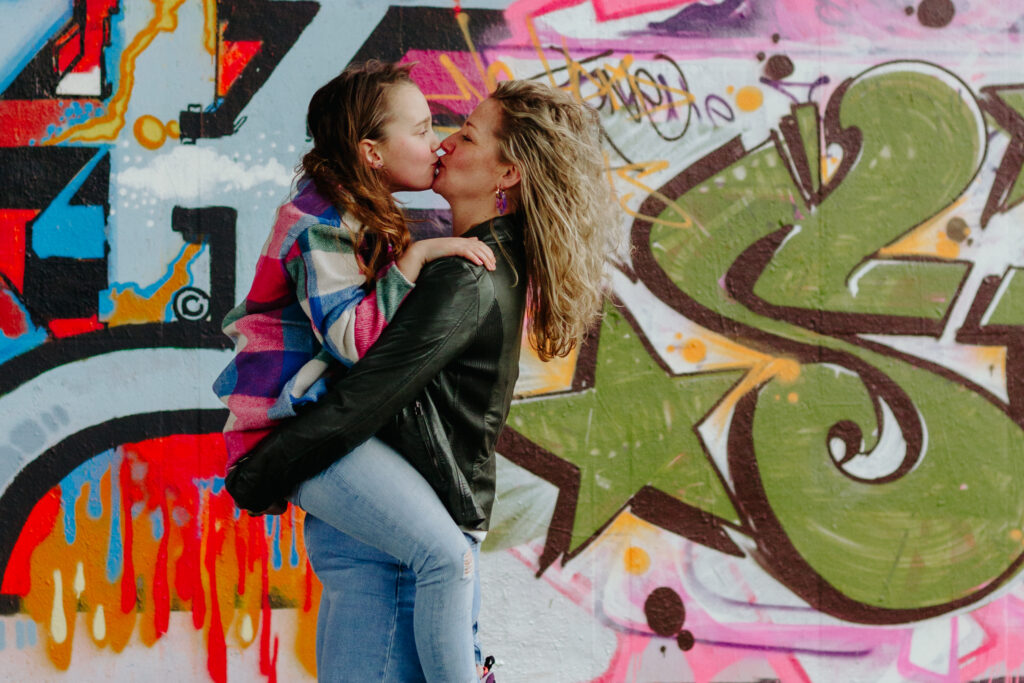 Moeder met dochter voor een graffity muur tijdens een fotoshoot.