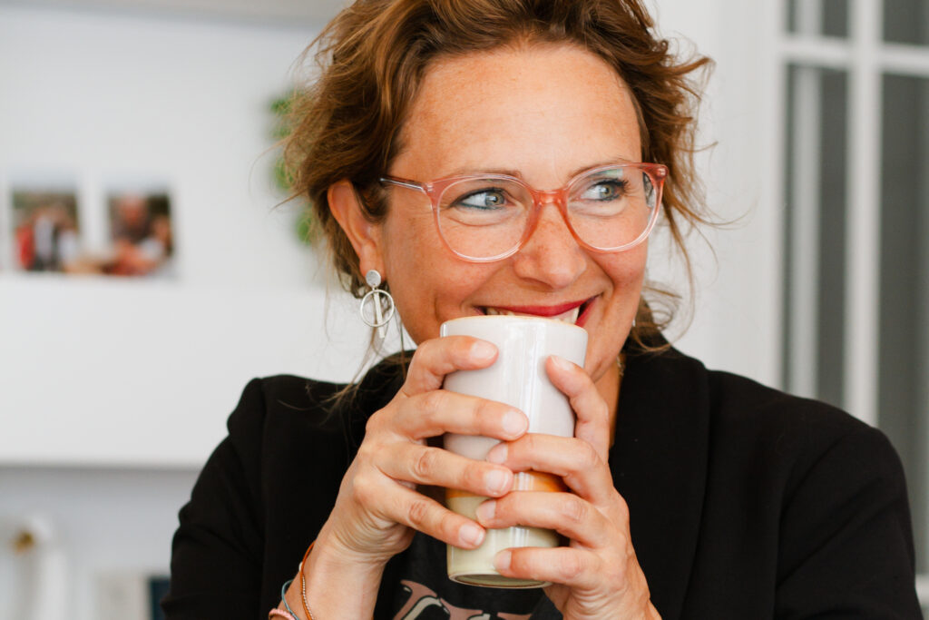 Interieurstyliste met een kop koffie in haar hand tijens een personal branding fotoshoot.