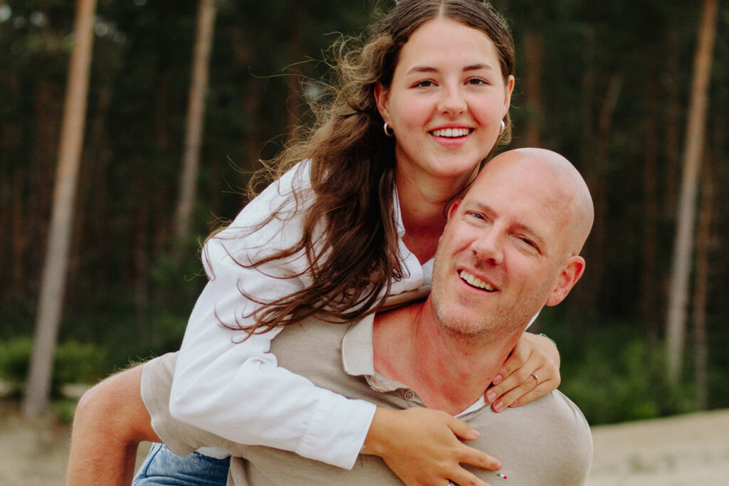 Vader met dochter op zijn rug tijdens een familieshoot.