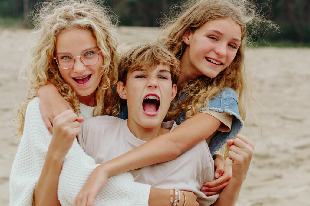 Drie vrolijke kinderen tijdens een familie fotoshoot.